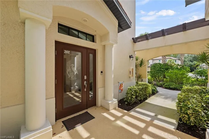 Archway entry with double glass panel doors and transom window