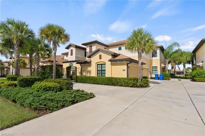 Mediterranean-inspired architecture with a barrel tile roof, stucco exterior, and attached garage