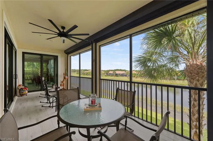 Screened lanai featuring light-toned flooring and a ceiling fan