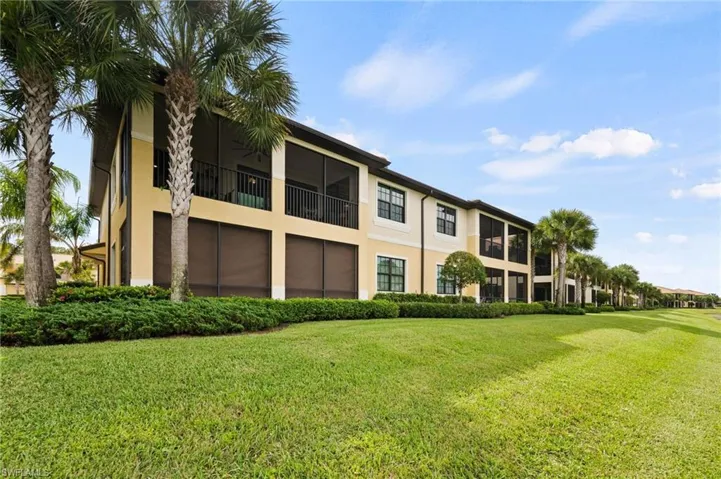 Exterior featuring a stucco finish, screened balconies, and mature palm trees