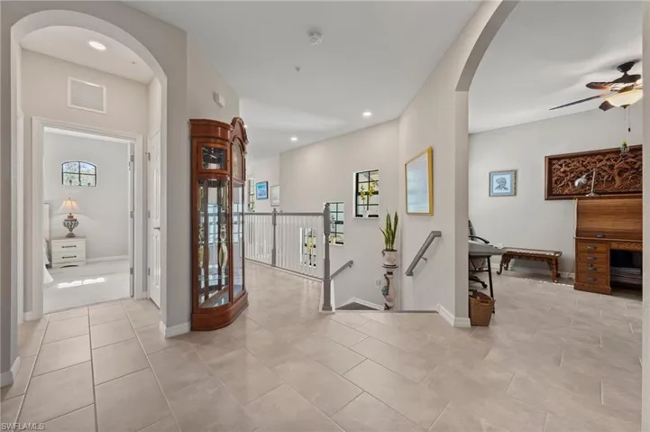 Archways, tiled flooring, recessed lighting, and a staircase with a white railing