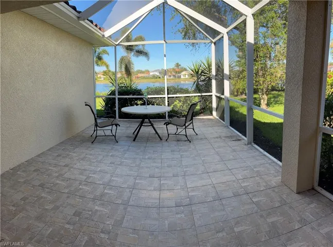 Sunroom featuring a water view and lofted ceiling