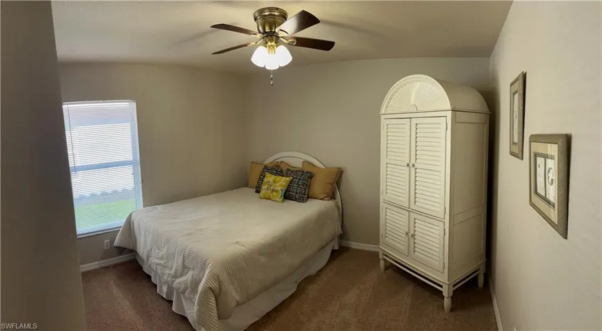Carpeted bedroom featuring a closet and ceiling fan