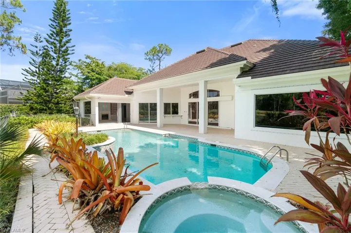 View of pool with a patio area and an in ground hot tub