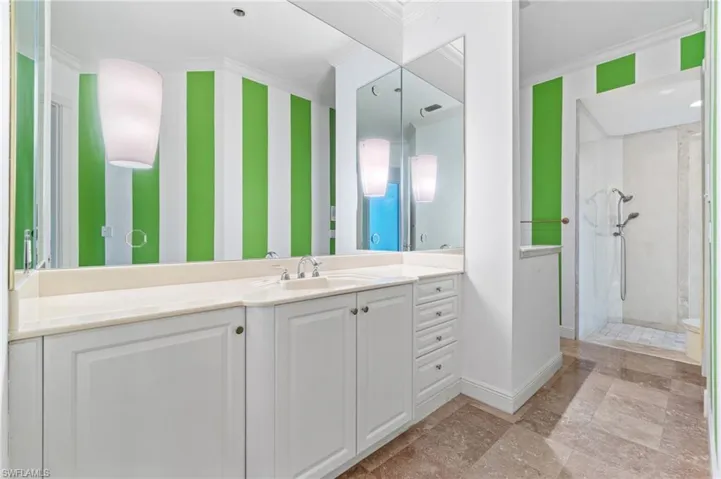 Bathroom featuring tile flooring, walk in shower, vanity, and ornamental molding