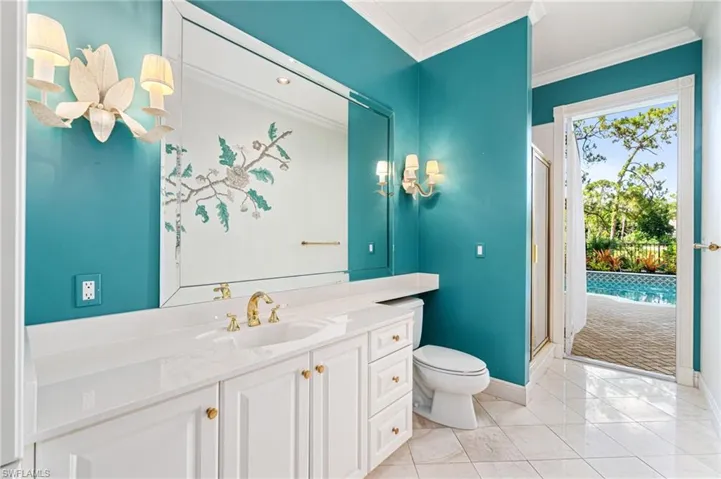 Bathroom with crown molding, a shower with door, tile floors, toilet, and large vanity