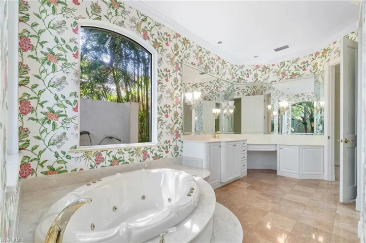 Bathroom featuring tile floors, ornamental molding, vanity, and a chandelier
