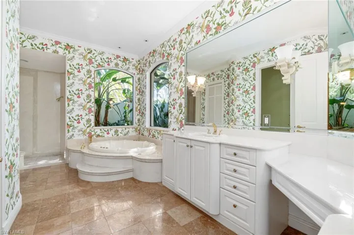 Bathroom featuring tile floors, crown molding, separate shower and tub, and vanity