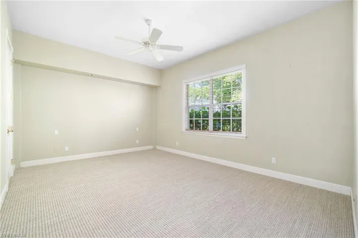 Carpeted empty room with ceiling fan