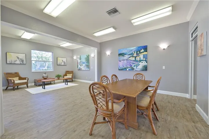 Clubhouse Dining area with light wood-style flooring and ornamental molding