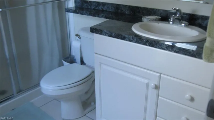 Bathroom featuring a shower stall, vanity, and tile patterned floors