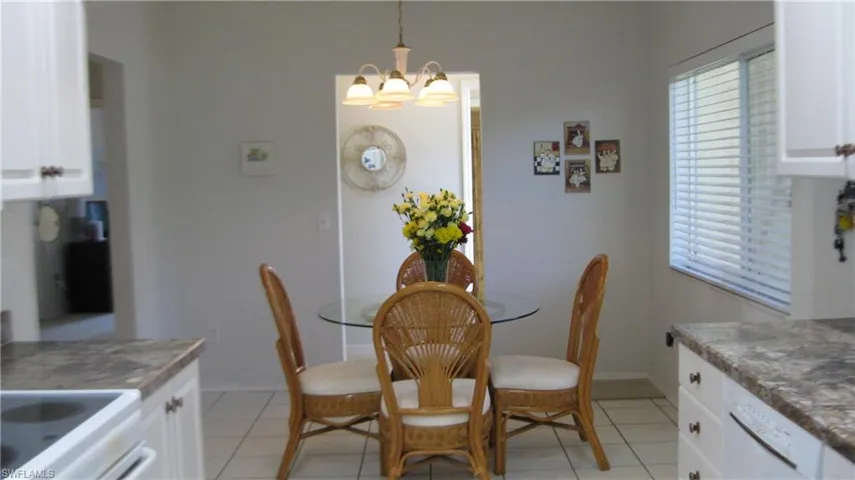 Eat in kitchen nook featuring light tile patterned flooring and a chandelier