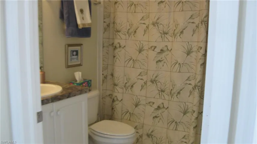 Bathroom featuring curtained shower/tub and vanity