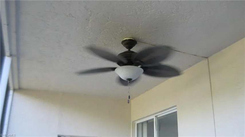 Detailed view of a ceiling fan and stucco siding