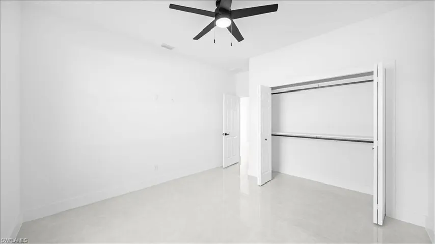 Unfurnished bedroom with ceiling fan, a closet, and finished concrete flooring