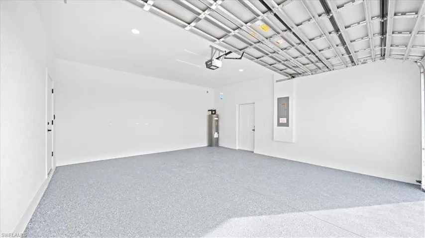 Garage featuring water heater and electric panel