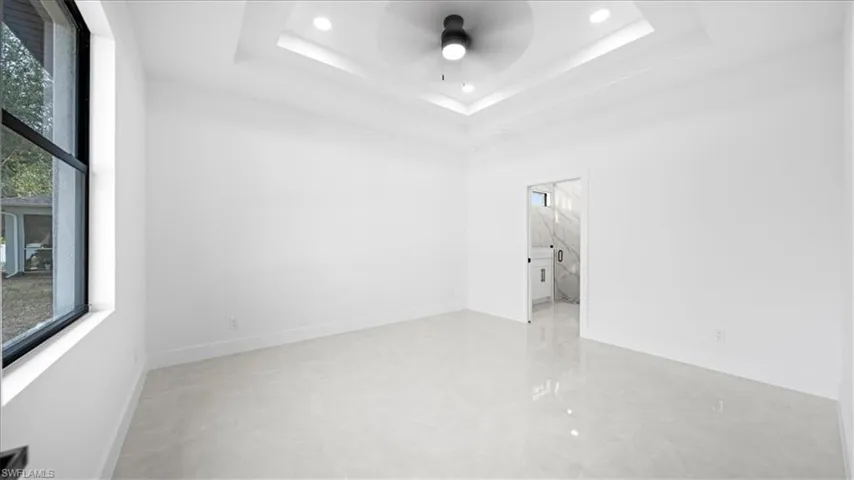 Unfurnished room with a ceiling fan and plenty of natural light