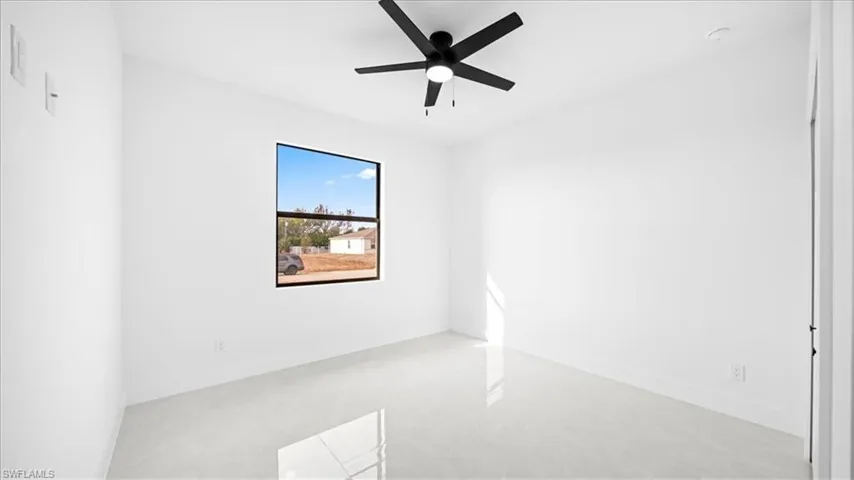 Spare room featuring a ceiling fan and baseboards
