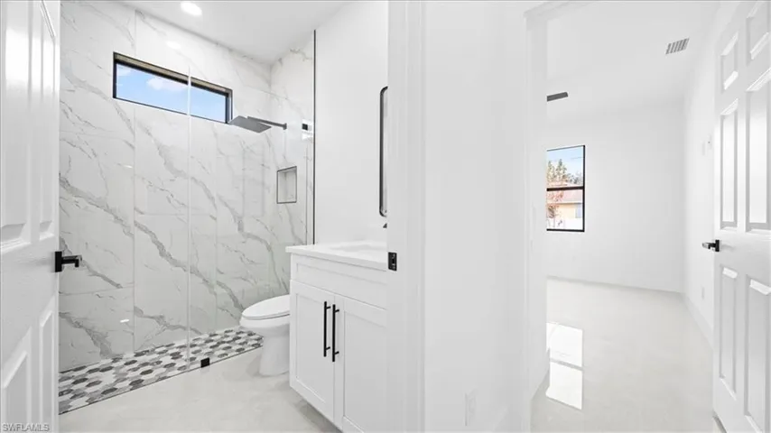 Full bathroom with vanity and a marble finish shower