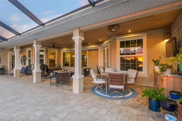 View of patio with outdoor dining space, outdoor lounge area, glass enclosure, and ceiling fan