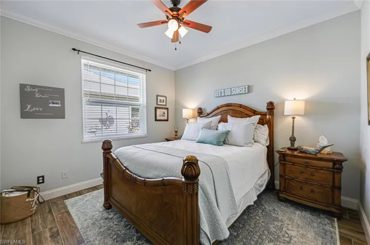 Bedroom with crown molding, ceiling fan, and wood tiled floors