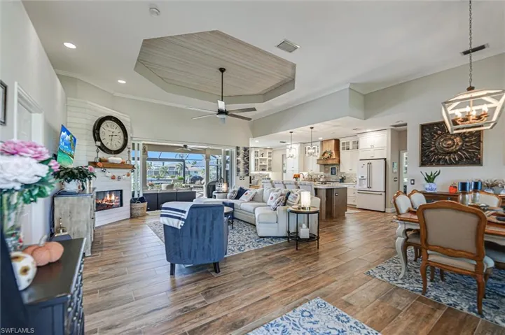 Living area with ornamental molding, a chandelier, a fireplace, wood finish floors, and recessed lighting