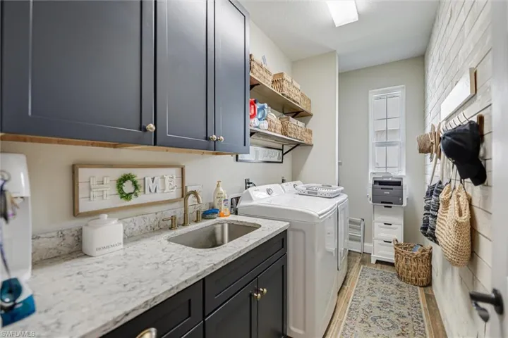 Washroom featuring cabinet space, dark wood finished floors, and washer and clothes dryer
