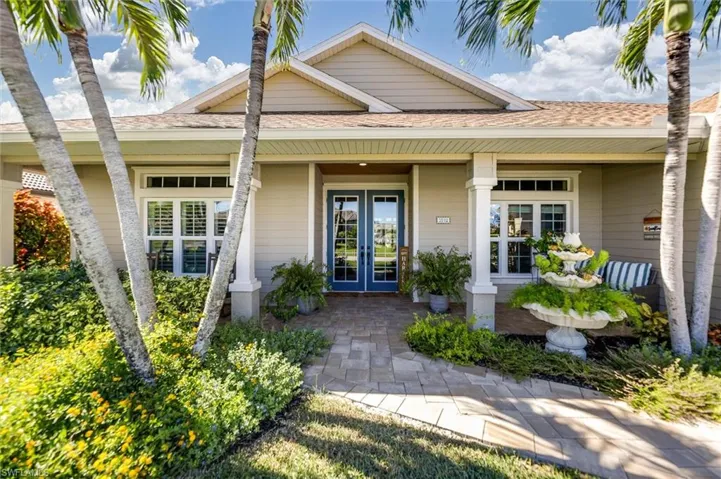 Doorway to property with french doors, covered porch, and roof with shingles