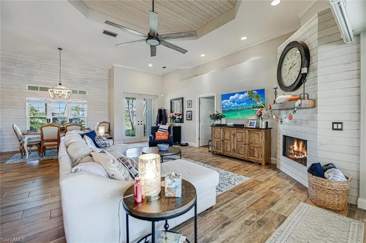Living room featuring a large fireplace, wooden ceiling, wood finish floors, ceiling fan, and recessed lighting