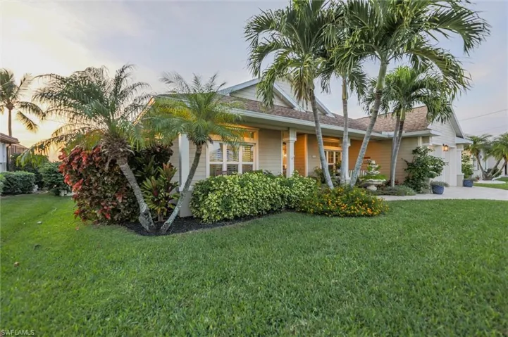 Ranch-style house featuring a lawn, concrete driveway, a shingled roof, and an attached garage