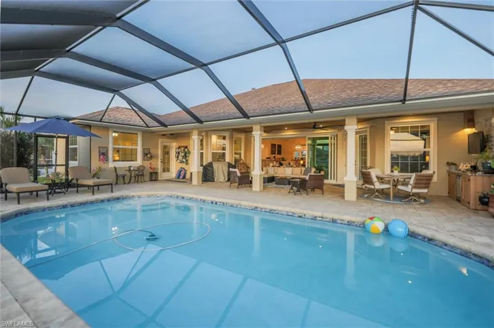 Swimming pool featuring a sunroom, a patio, a lanai, outdoor dining space, and an outdoor hangout area