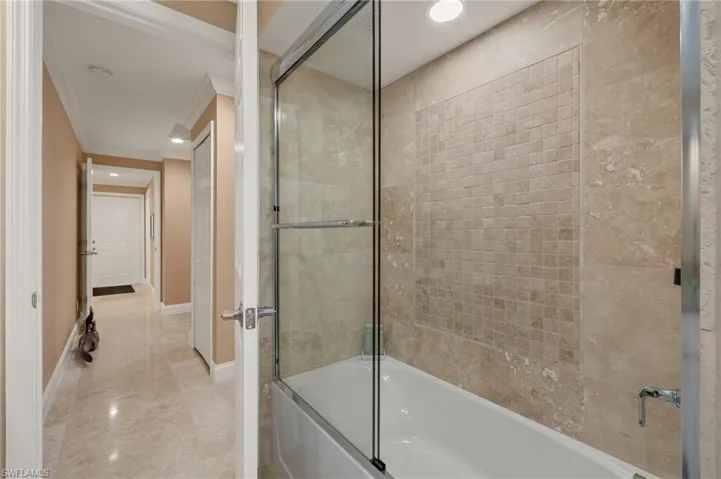 Bathroom featuring enclosed tub / shower combo, ornamental molding, and recessed lighting