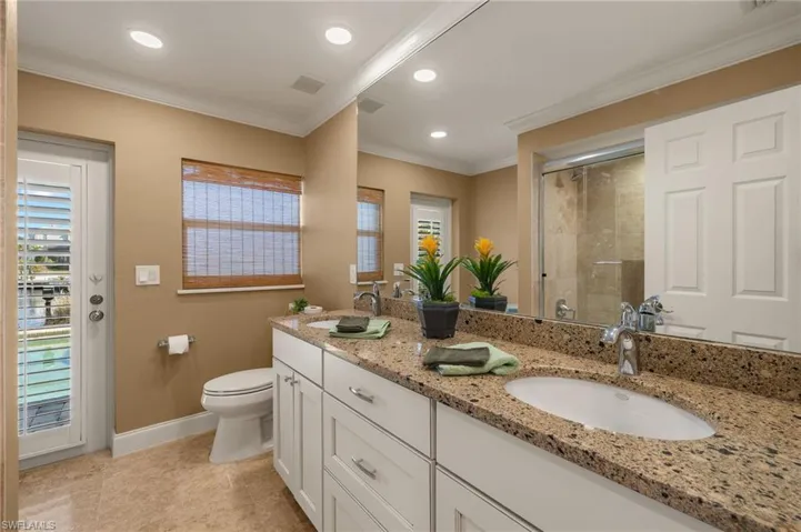Bathroom featuring ornamental molding, a shower stall, double vanity, recessed lighting, and light tile patterned flooring