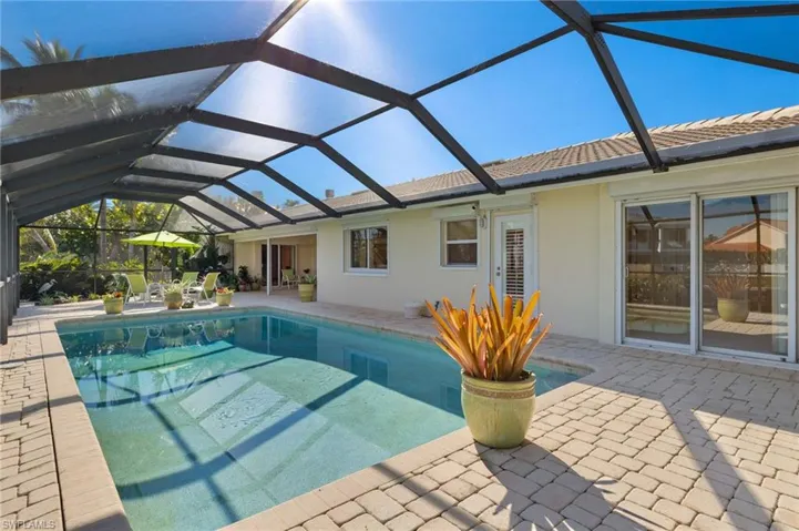 Swimming pool featuring a patio area, a sunroom, and a lanai