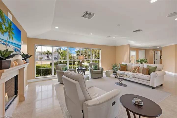 Living room with recessed lighting, a high end fireplace, and light tile patterned floors