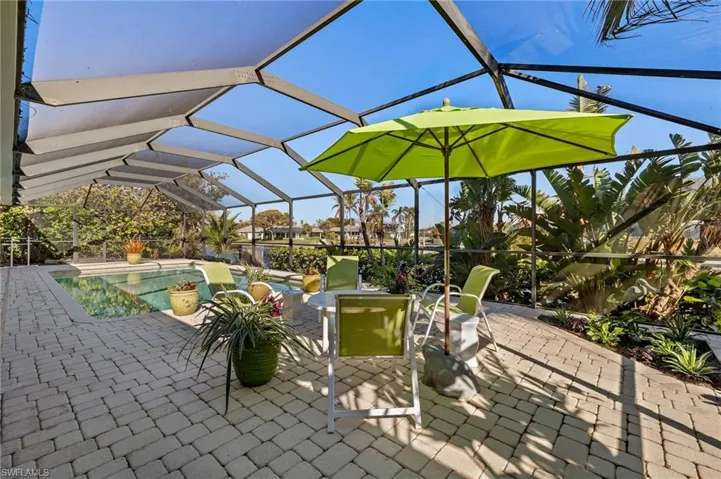 View of patio with glass enclosure, a sunroom, and an outdoor pool