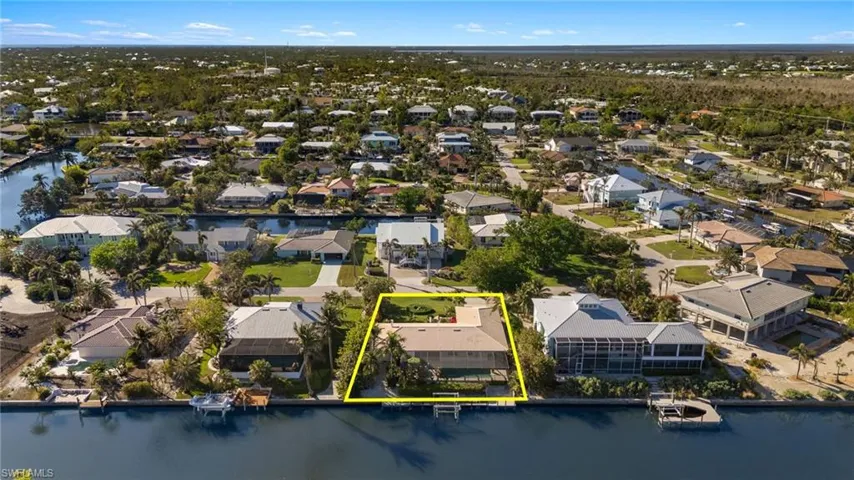 Aerial view of residential area featuring a nearby body of water and property boundaries highlighted