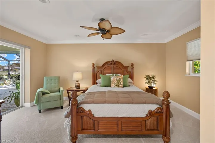 Carpeted bedroom featuring access to exterior, ornamental molding, and ceiling fan