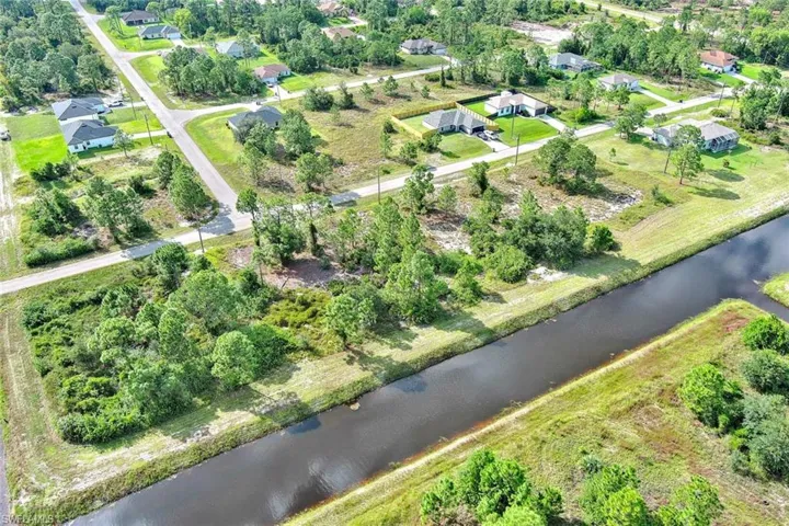 View of property location with a large body of water and a tree filled landscape
