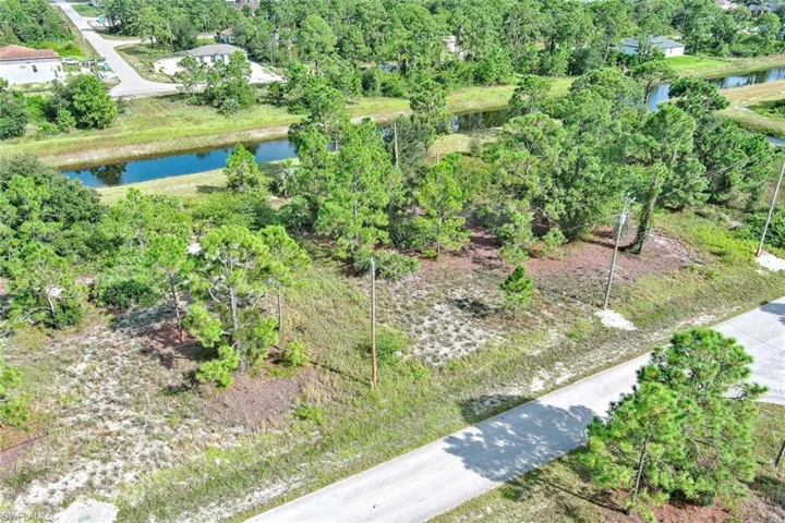 Aerial overview of property's location with a nearby body of water and a tree filled landscape