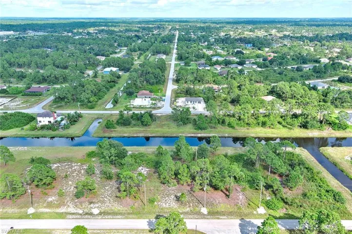 Aerial overview of property's location featuring a large body of water and a tree filled landscape