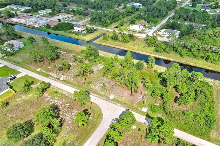 Aerial view of property's location with a large body of water and a tree filled landscape