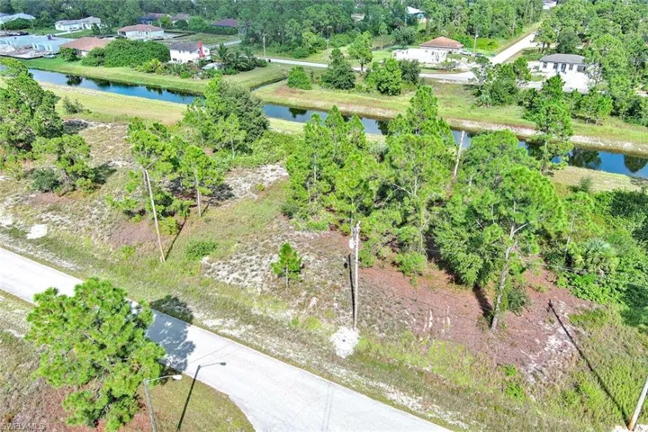 View of property location with a tree filled landscape and a large body of water