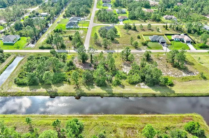 Aerial overview of property's location featuring a nearby body of water and a tree filled landscape