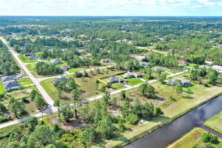 Aerial view of property's location featuring a nearby body of water and nearby suburban area