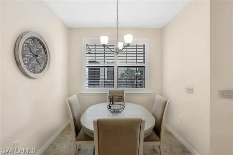 Dining space featuring baseboards, a healthy amount of sunlight, and a notable chandelier