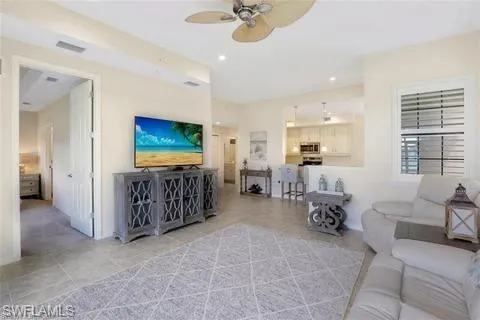 Tiled living area with a ceiling fan, recessed lighting, and visible vents