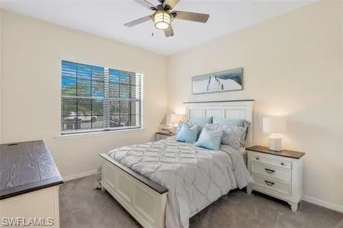 Bedroom with baseboards, ceiling fan, and light carpet