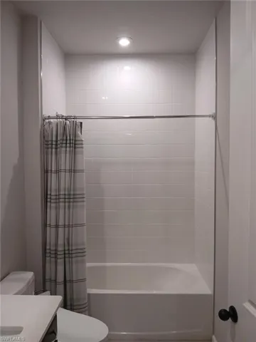 Full bath with vanity, shower / tub combo, and recessed lighting