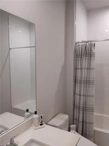 Bathroom with vanity and shower / bath combo with shower curtain
